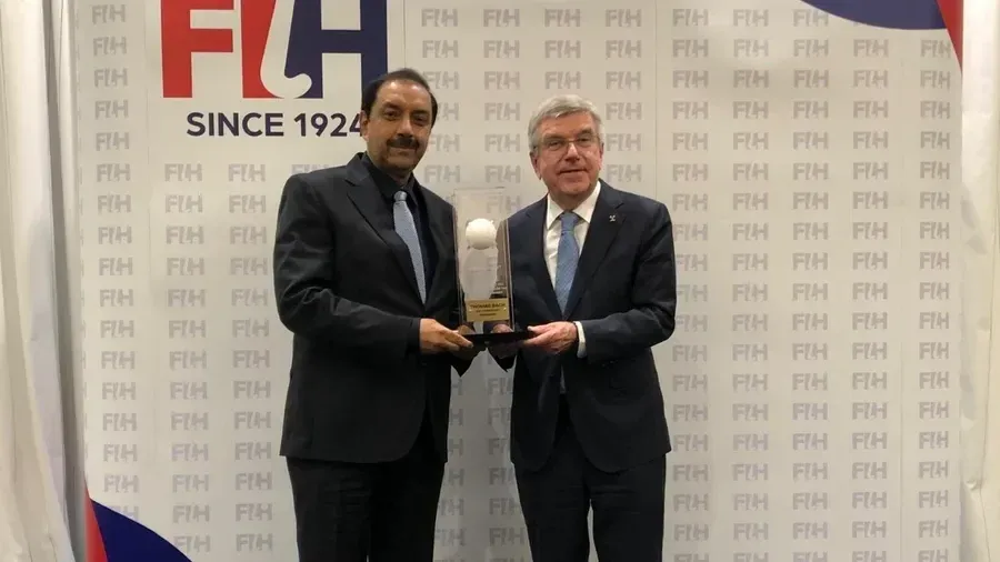 Tayyab Ikram presents IOC Honorary President Thomas Bach with the FIH Lifetime Achievement Award